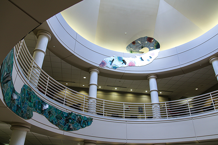 Metallic panels trace the walls between the floors of an interiod rotunda