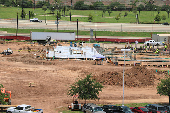 A dirt construction site with foundation being made