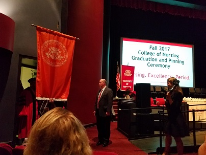 A person carrying a red banner towards a stage