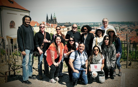 A group of students and an instructor with rooftops of a town in the background