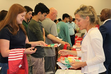 A woman giving a handout to a young lady