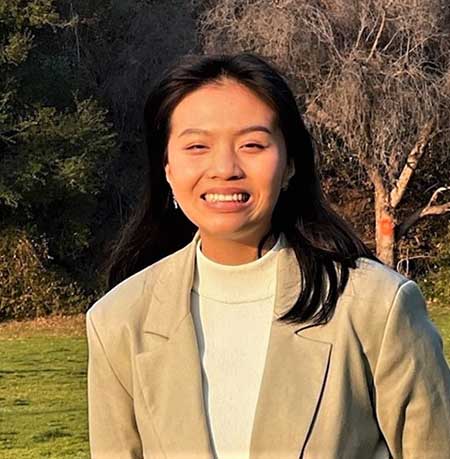 Portrait of an asian woman smiling outside.