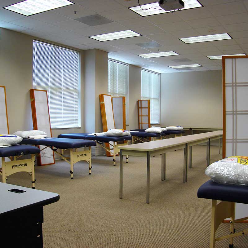 A classroom with a row treatment tables with pillows and partitions.